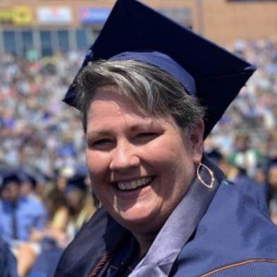 Ortiz smiling in her graduation regalia.