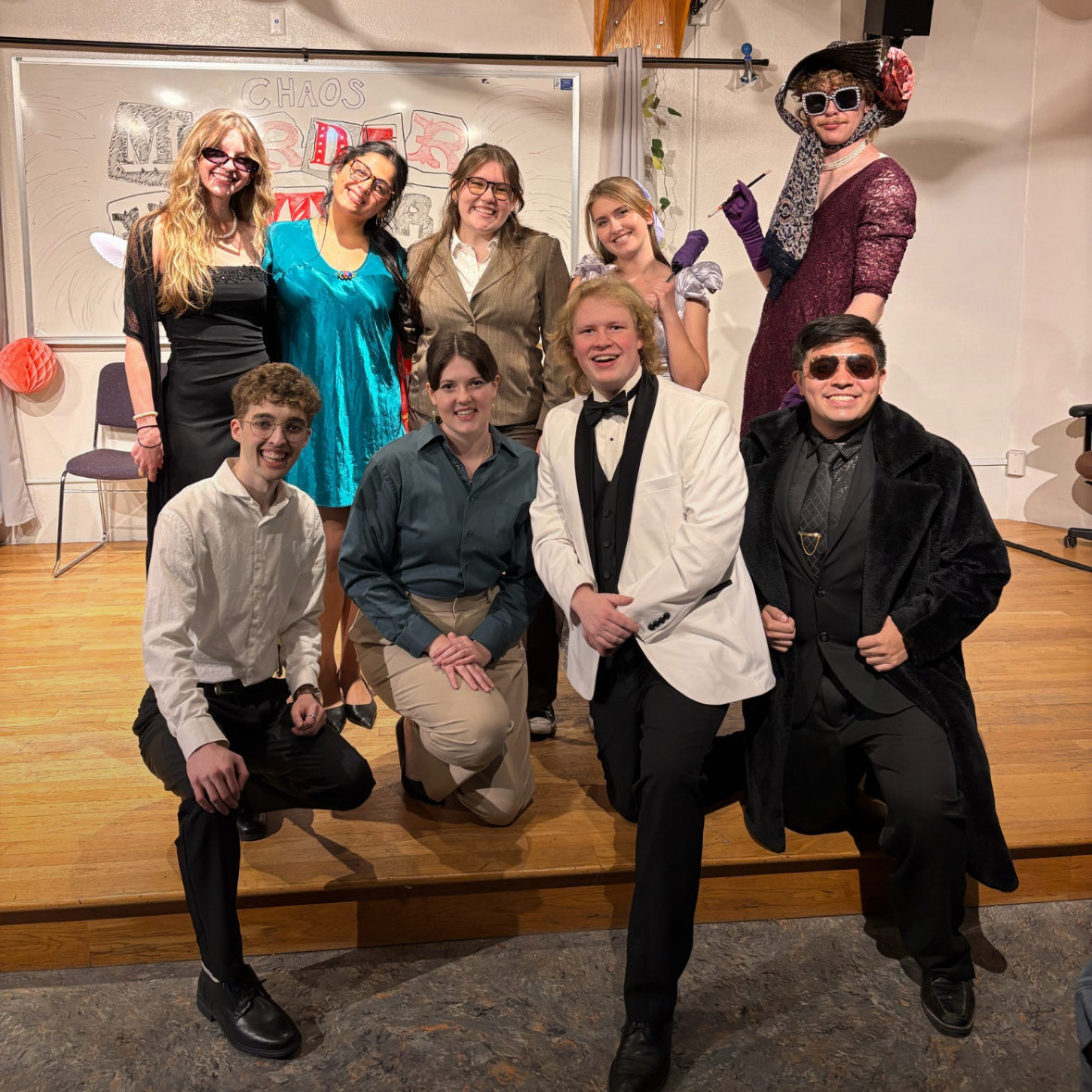 Chaos Improv members in costume for a murder-mystery-themed long-form show. From left to right: Abigail Pilgrim, Abby Haimoff, Jessica Riley, Lexi Murphy, Henry McBride (top), Ryan Mauck, Dee Dee Martin, Nicolas Weary, Markus Rodriguez (bottom). Not pictured: Nolan Bond