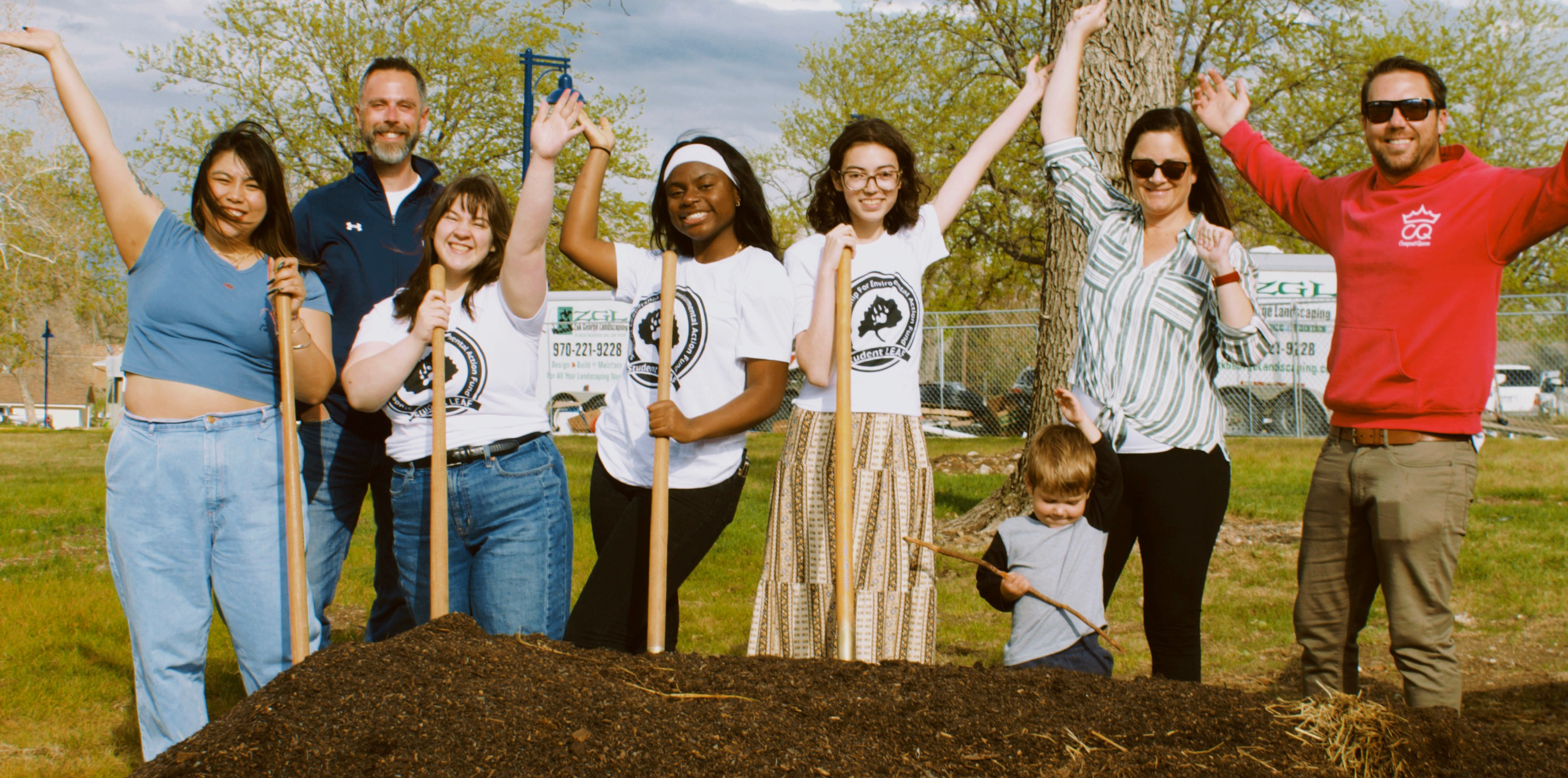 A group of Student leaf students holding shovels near a pile of compost soil outside