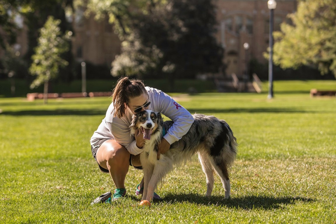 UNC Student hugging her pet dog outside a UNC Hall