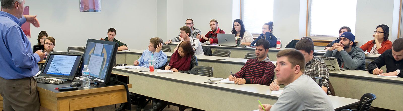 Business students sitting in classroom while progessor lectures