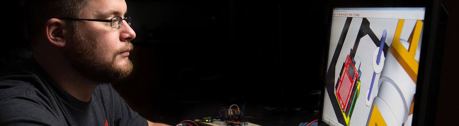 Student in robotics lab looking at computer