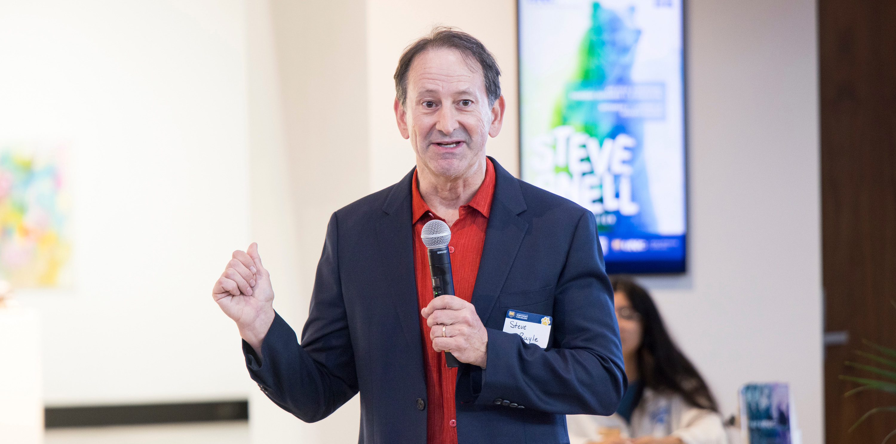Stephen Ruyle talking to a crowd holding a microphone