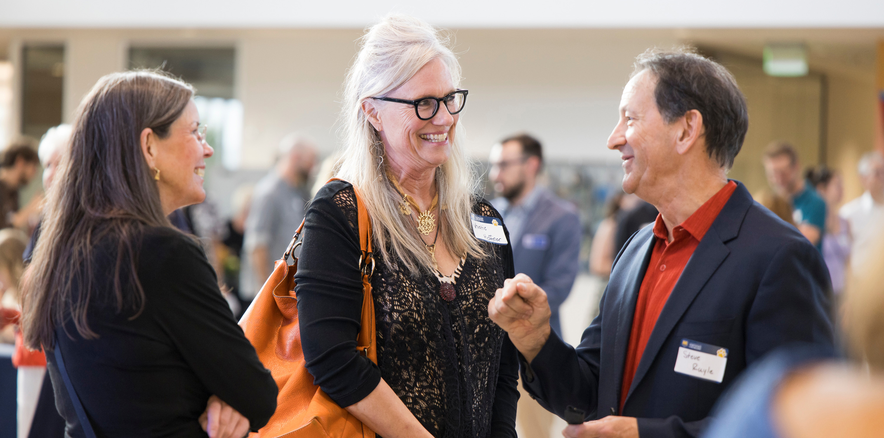 Three people talking and smiling inside Campus Commons