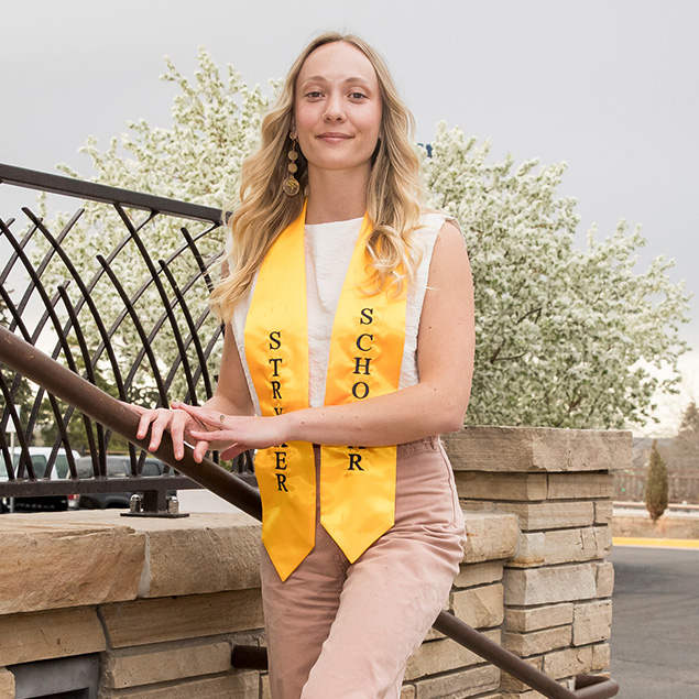 Madeline standing on stairs outside looking at the camera