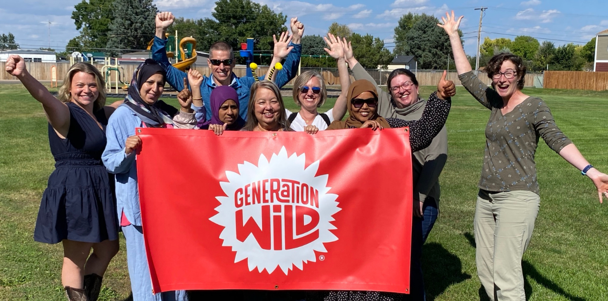 A group of people smiling and holding a banner that reads "Generation Wild"